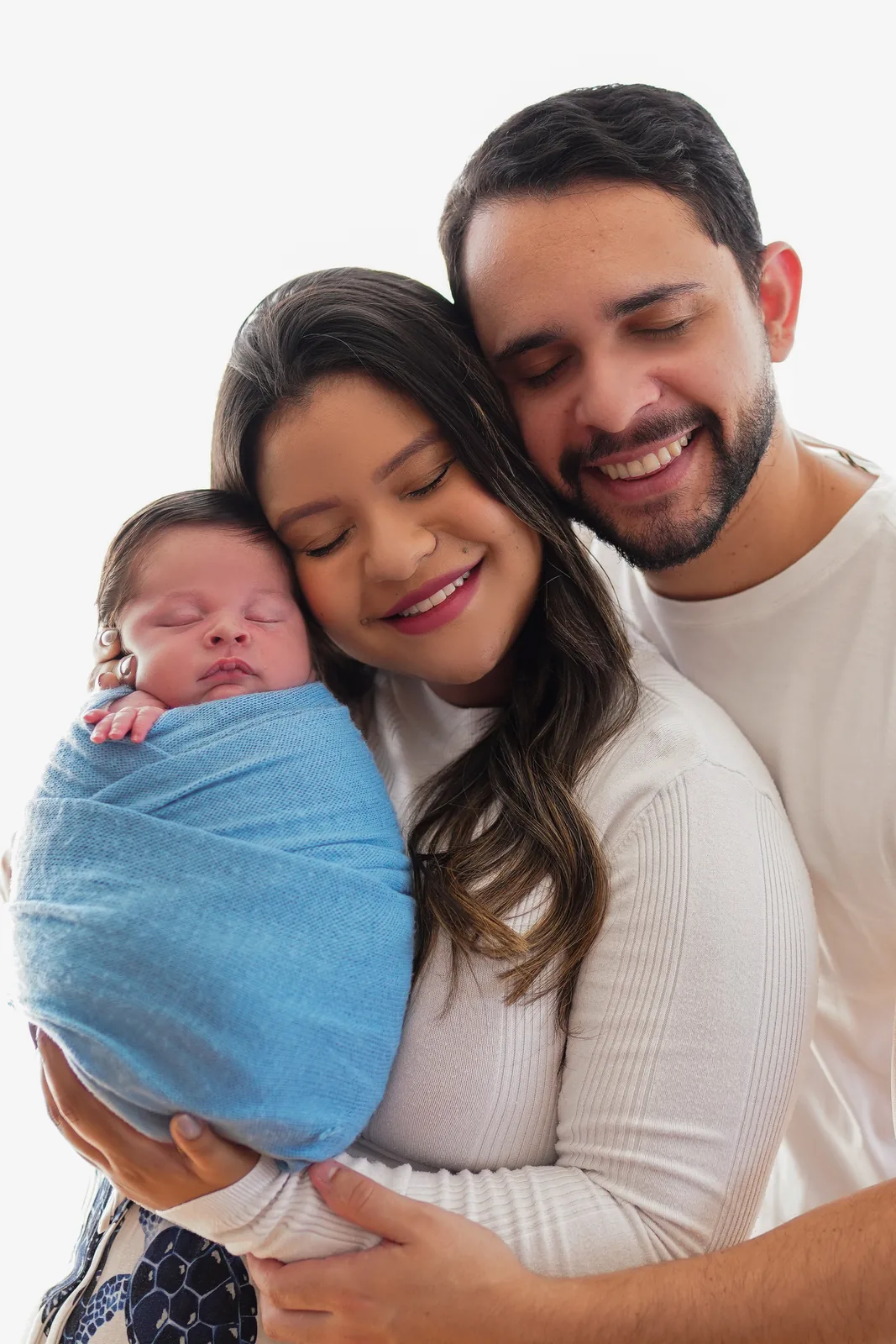 Família reunida com o recém-nascido em manta azul, outro ângulo, sorrindo