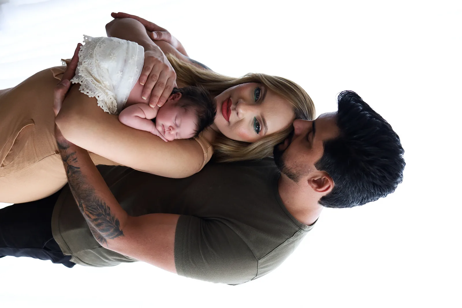 Mãe olhando para a bebê no colo, sorrindo, manta rosa