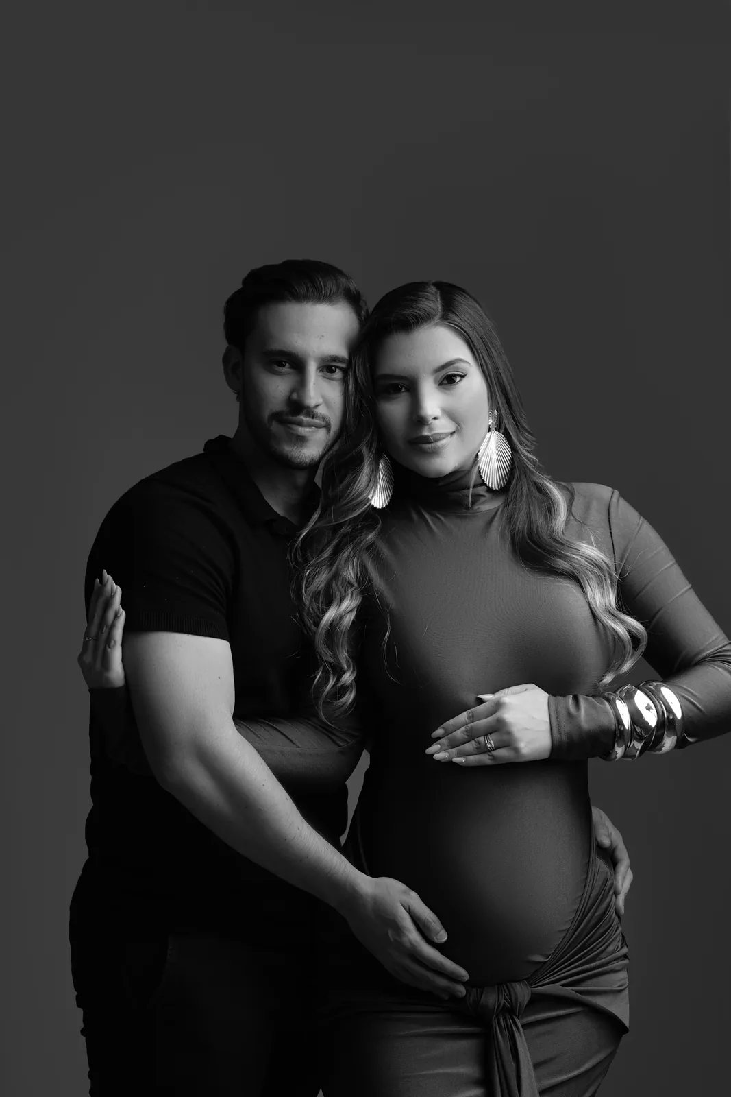 Casal grávido em retrato de perto, vestido marrom, em preto e branco