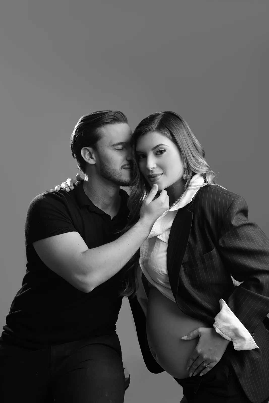 Casal grávido em retrato de perto, blazer, mesma cena em preto e branco