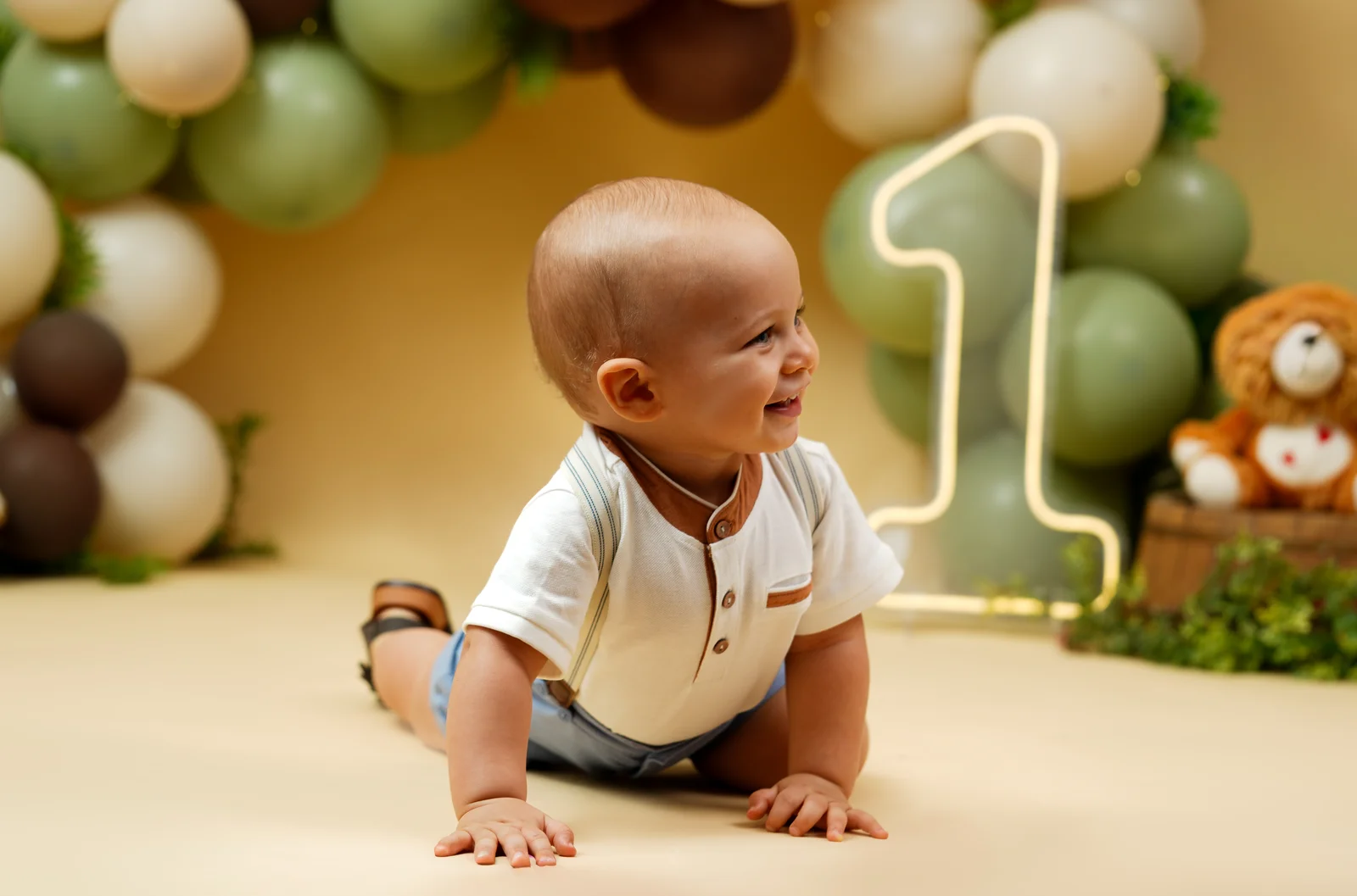 Bebê engatinhando em frente à decoração de balões — ensaio smash the cake