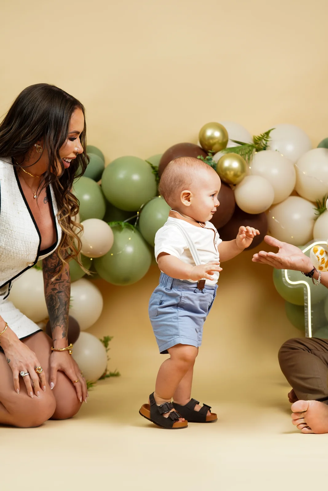 Bebê de pé com a mãe agachada ao lado — ensaio smash the cake