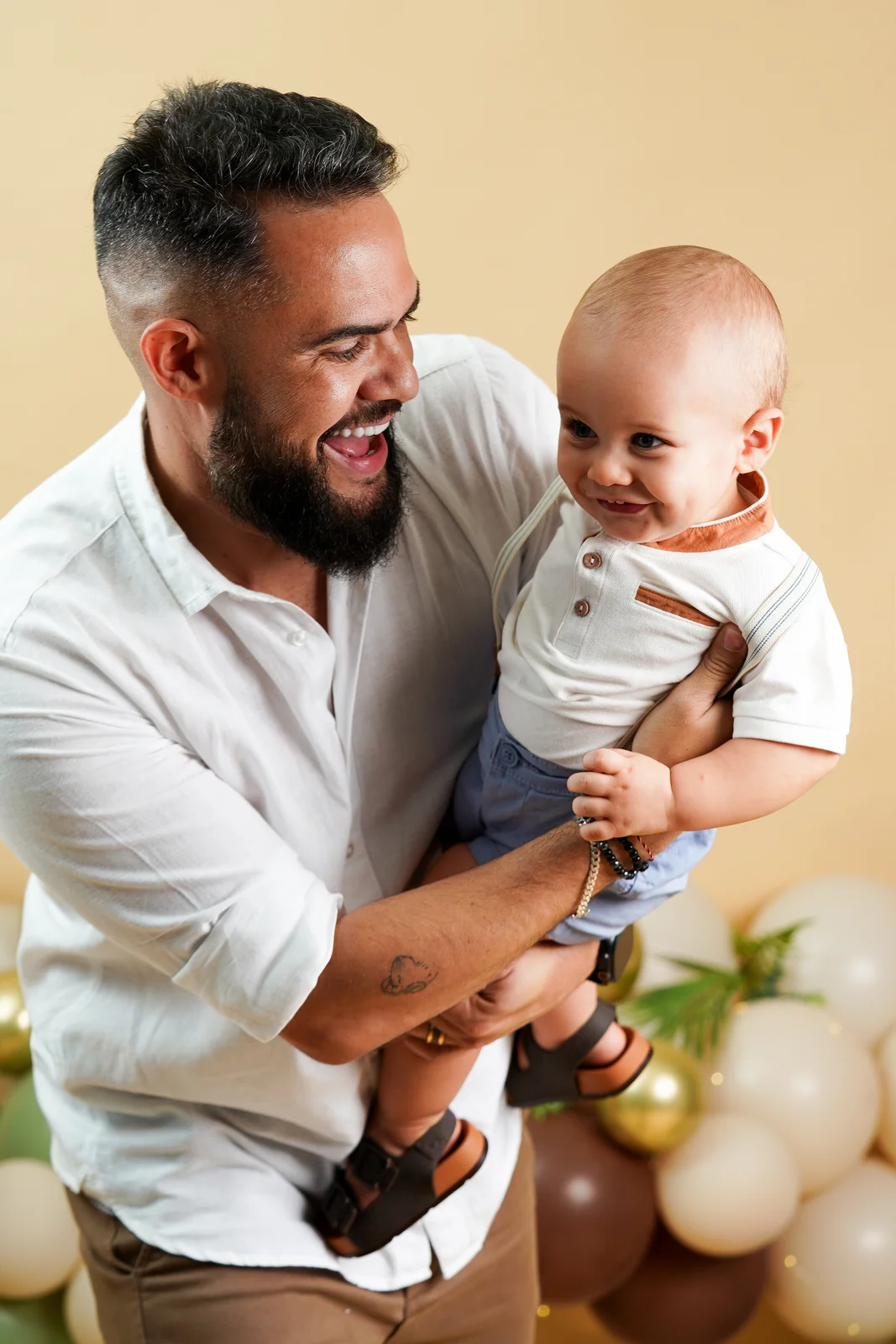 Pai segurando o bebê no colo, sorrindo — ensaio smash the cake