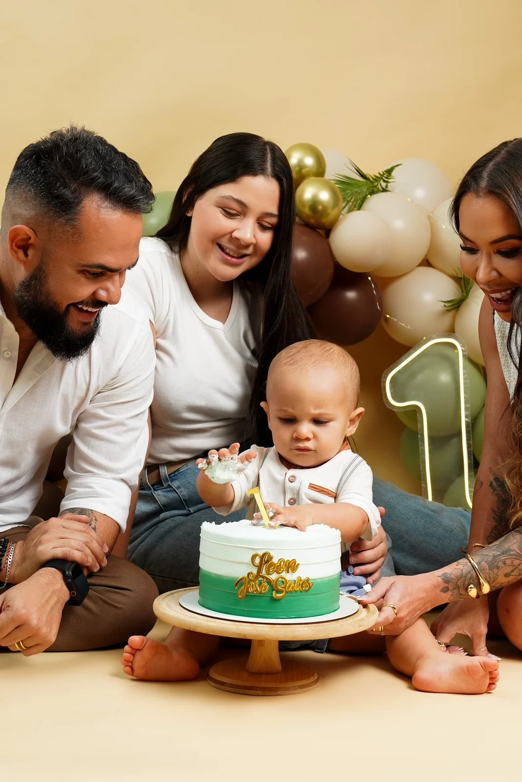 Pai, mãe e bebê reunidos perto do bolo — ensaio smash the cake