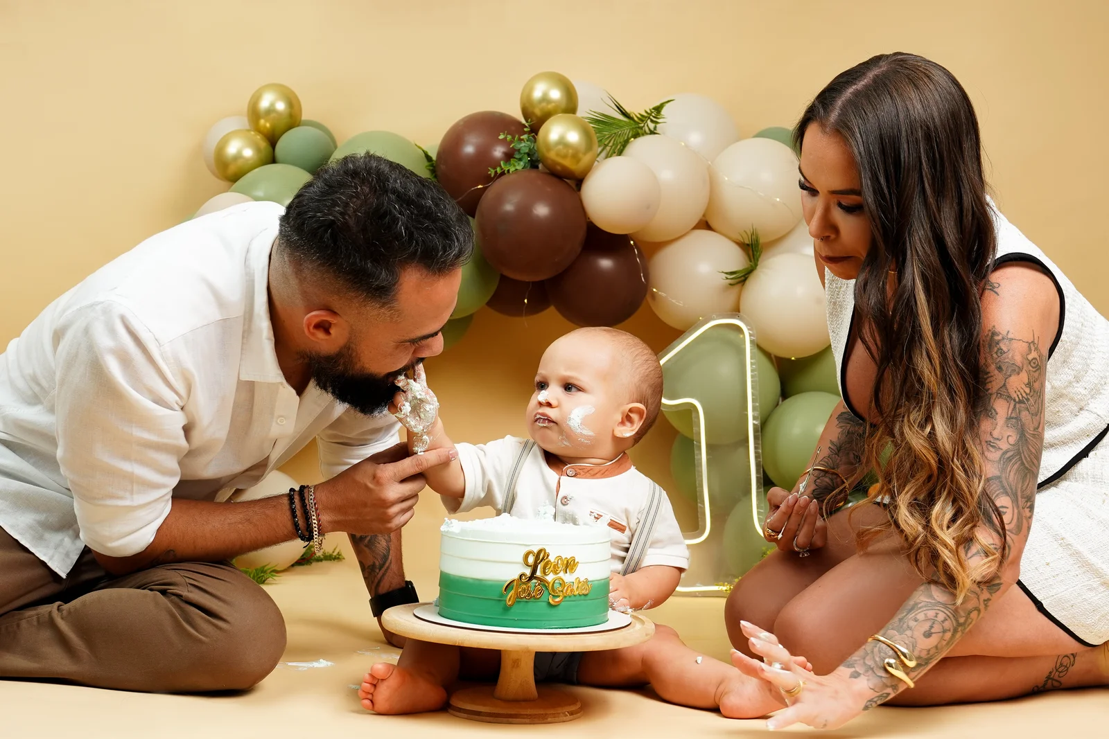 Pai e mãe ajudando o bebê com o bolo — ensaio smash the cake
