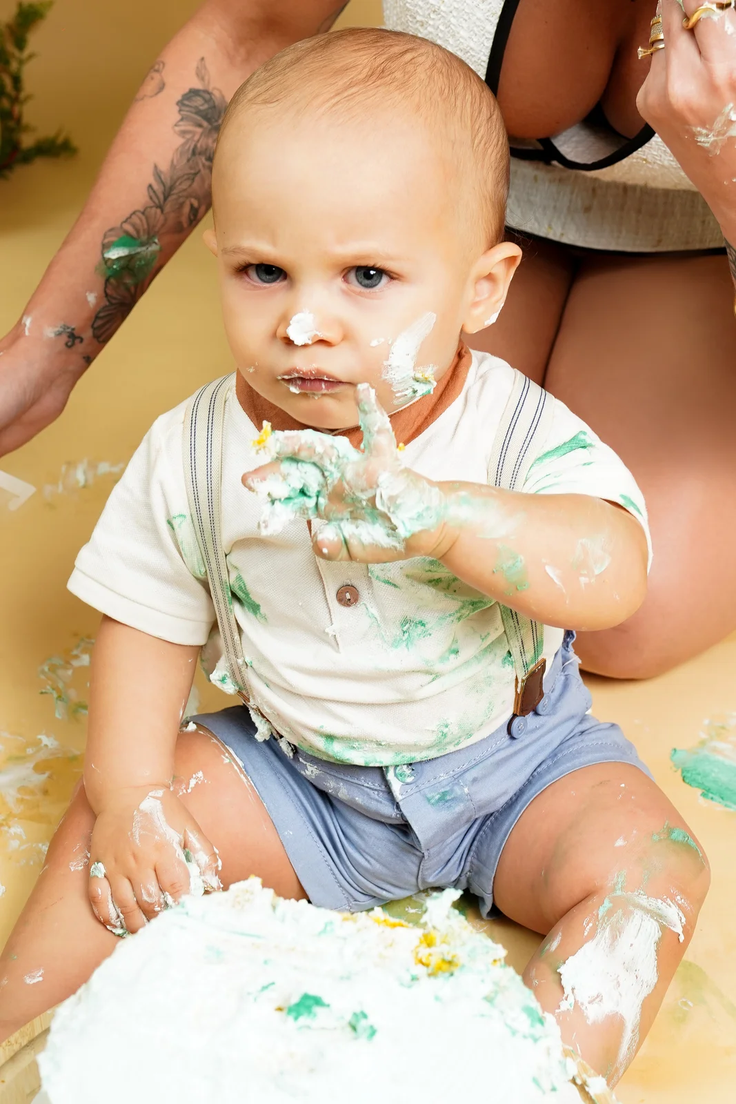 Bebê sorrindo, sujo de bolo, em frente à decoração de balões — ensaio smash the cake