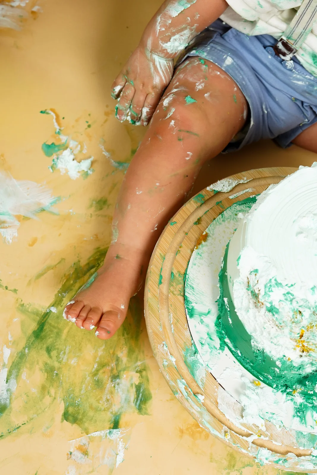 Detalhe do pé do bebê apoiado no bolo — ensaio smash the cake