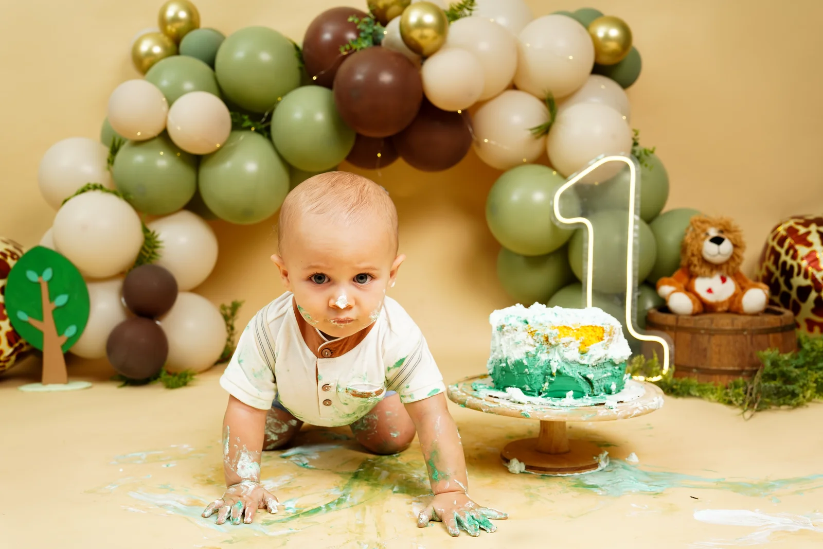 Mãe segurando o bebê perto do bolo, sorrindo — ensaio smash the cake