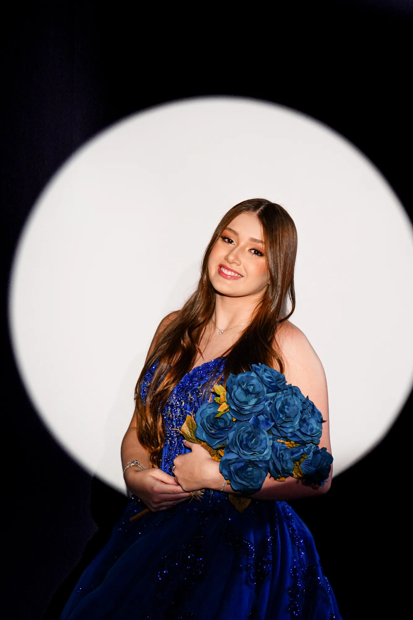Debutante sentada em pódio branco, vestido rosé, cake smash de 15 anos em estúdio