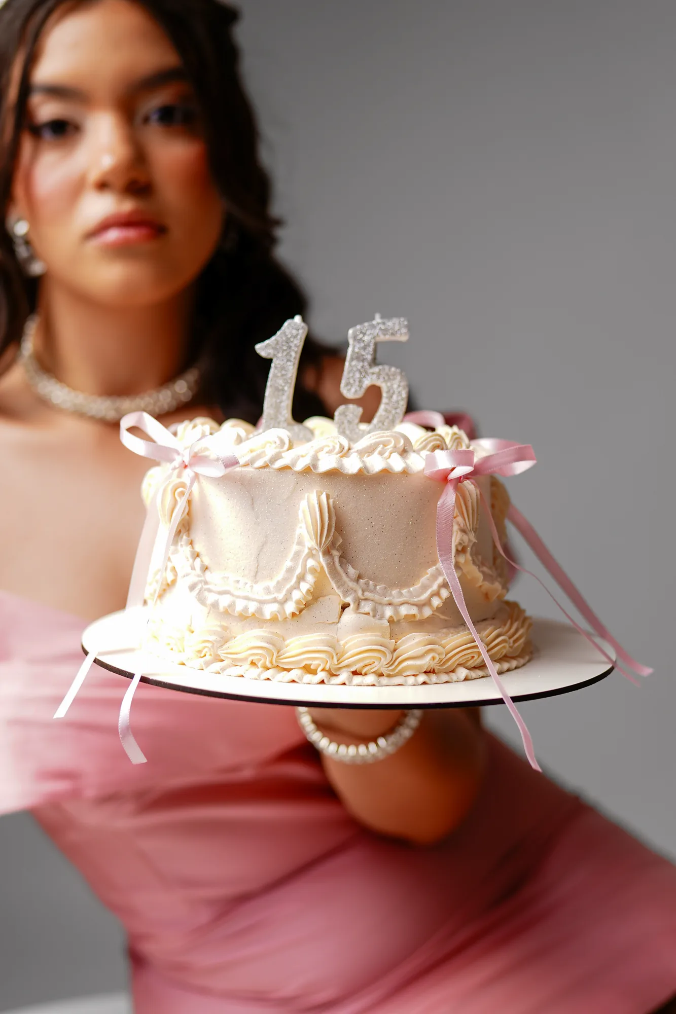 Debutante lendo convite save the date sentada em cadeira de diretor, ensaio em estúdio