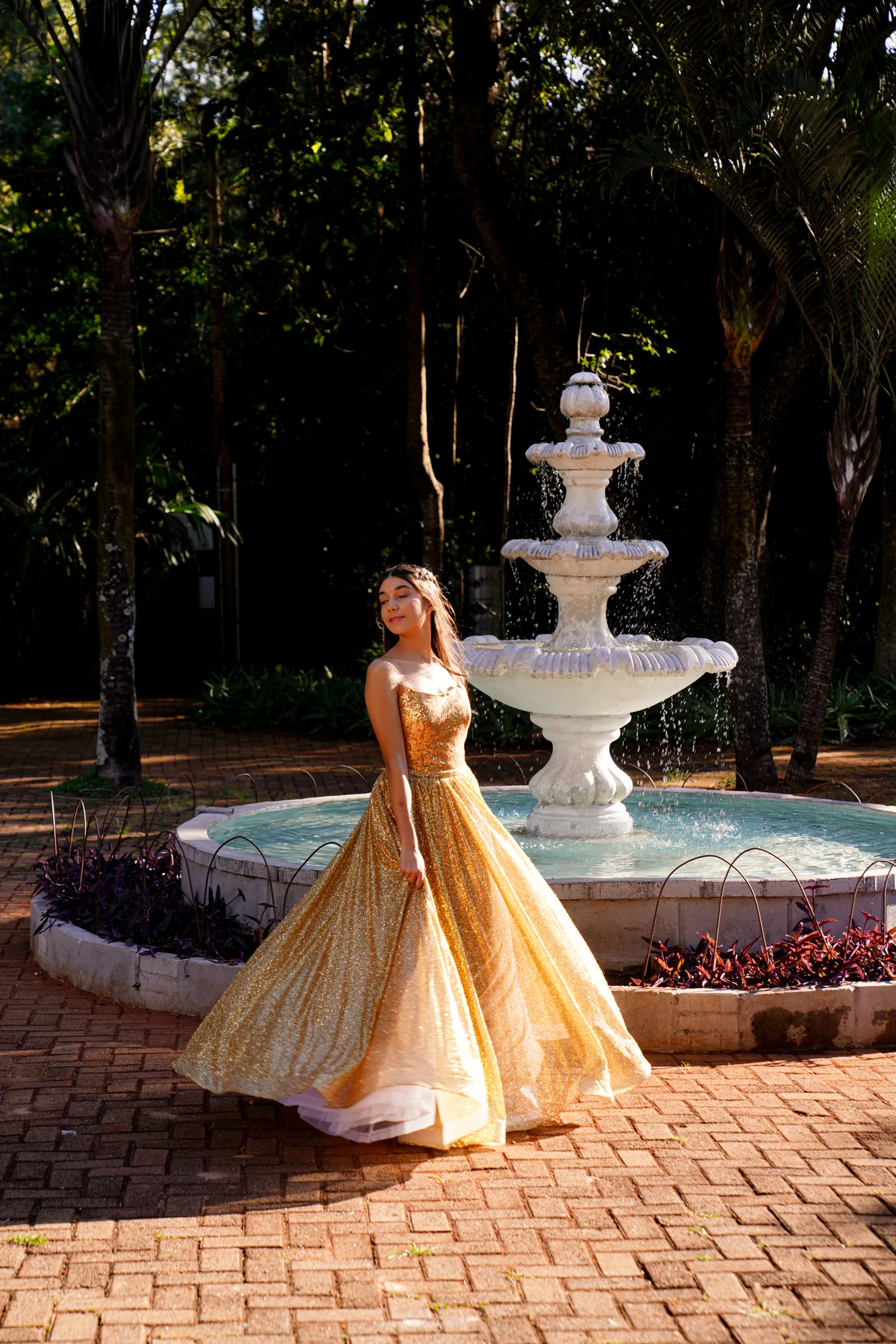 Debutante de vestido dourado junto à fonte do Jardim Botânico de Brasília