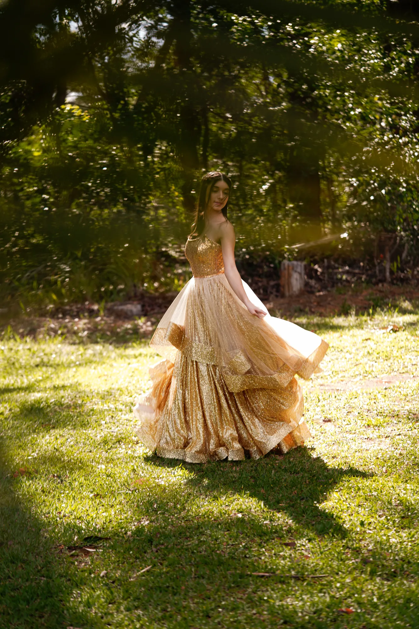 Debutante rodopiando de vestido dourado no gramado do Jardim Botânico de Brasília