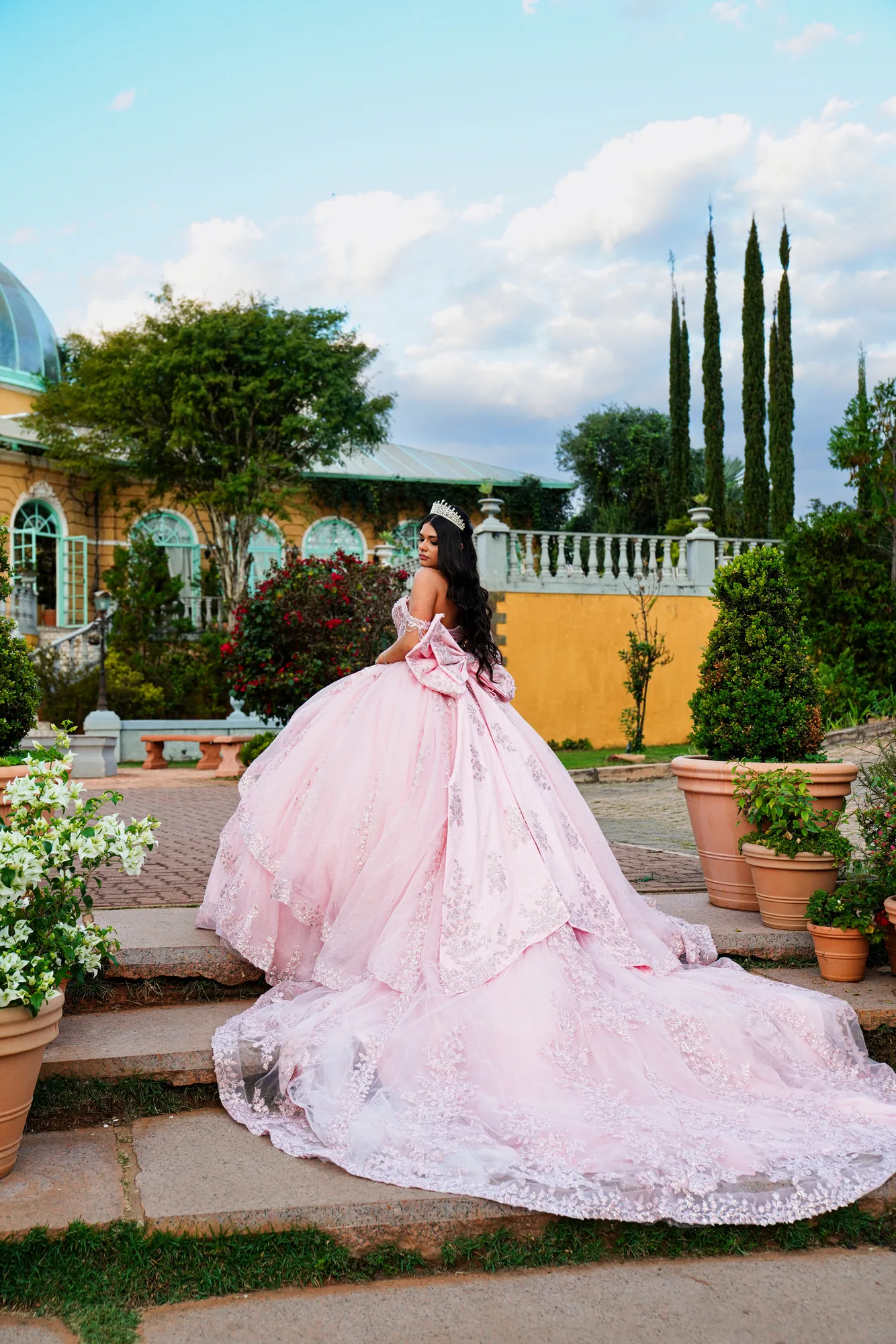 Debutante de vestido rosé ao lado de um cavalo no gramado da Villa Giardini