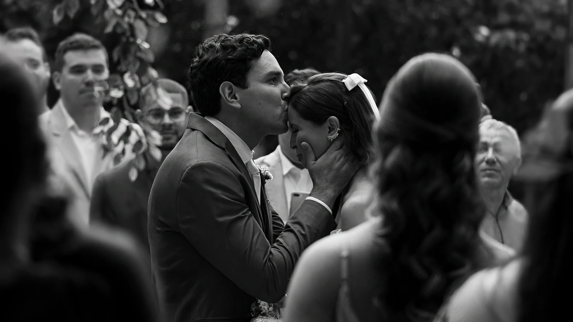 Noivo beijando a testa da noiva durante a cerimônia, em preto e branco — fotografia de casamento em Brasília