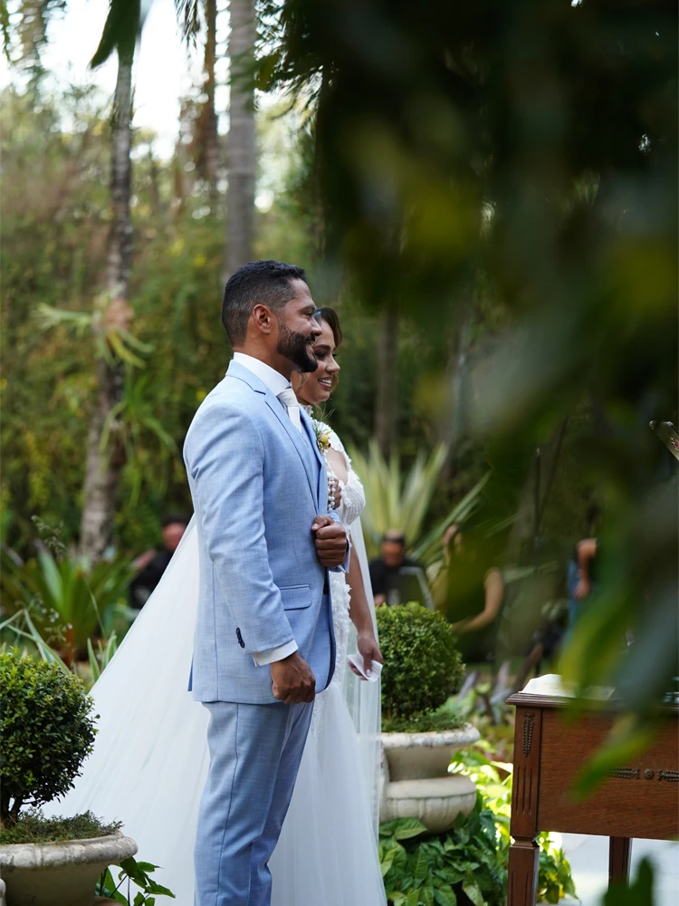Noivo de perfil sorrindo ao lado da noiva, cerimônia entre a vegetação — casamento ao ar livre em Brasília