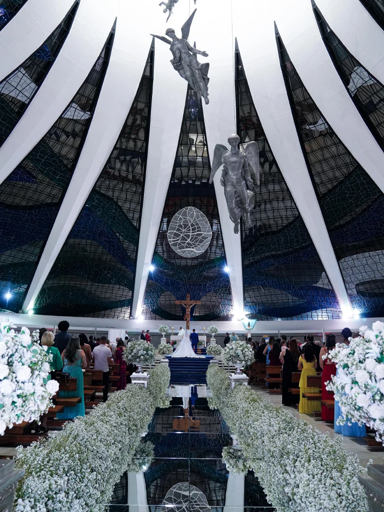 Vista de baixo dos vitrais e anjos suspensos da Catedral de Brasília durante uma cerimônia de casamento