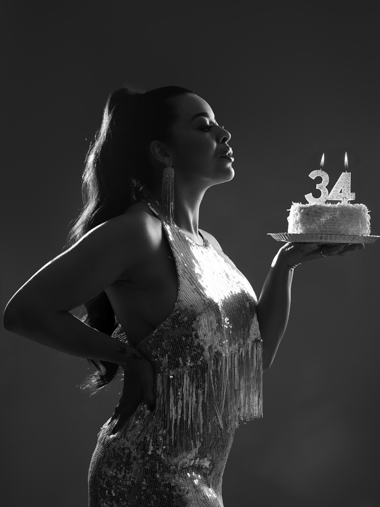 Retrato de perfil segurando um bolo de aniversário de 34 anos, em contraluz — ensaio feminino em Brasília