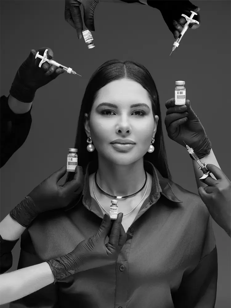 Mulher cercada por mãos com seringas e frascos, retrato em preto e branco — ensaio de branding para harmonização facial em estúdio, Brasília