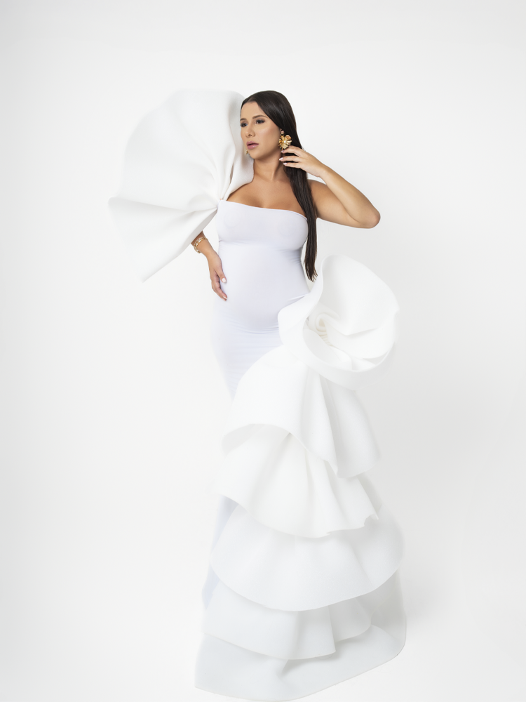 Gestante em vestido branco com babados escultóricos, fundo branco — ensaio gestante editorial em estúdio no Lago Sul, Brasília