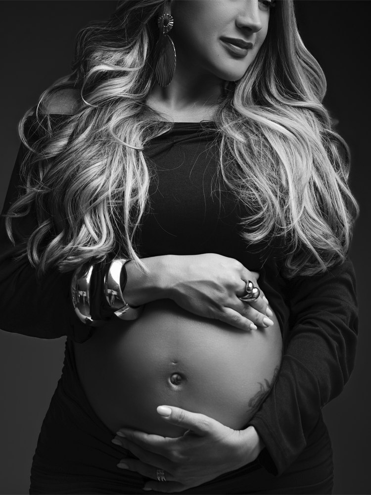 Mãos da gestante sobre a barriga, retrato em preto e branco — ensaio gestante em estúdio no Lago Sul, Brasília