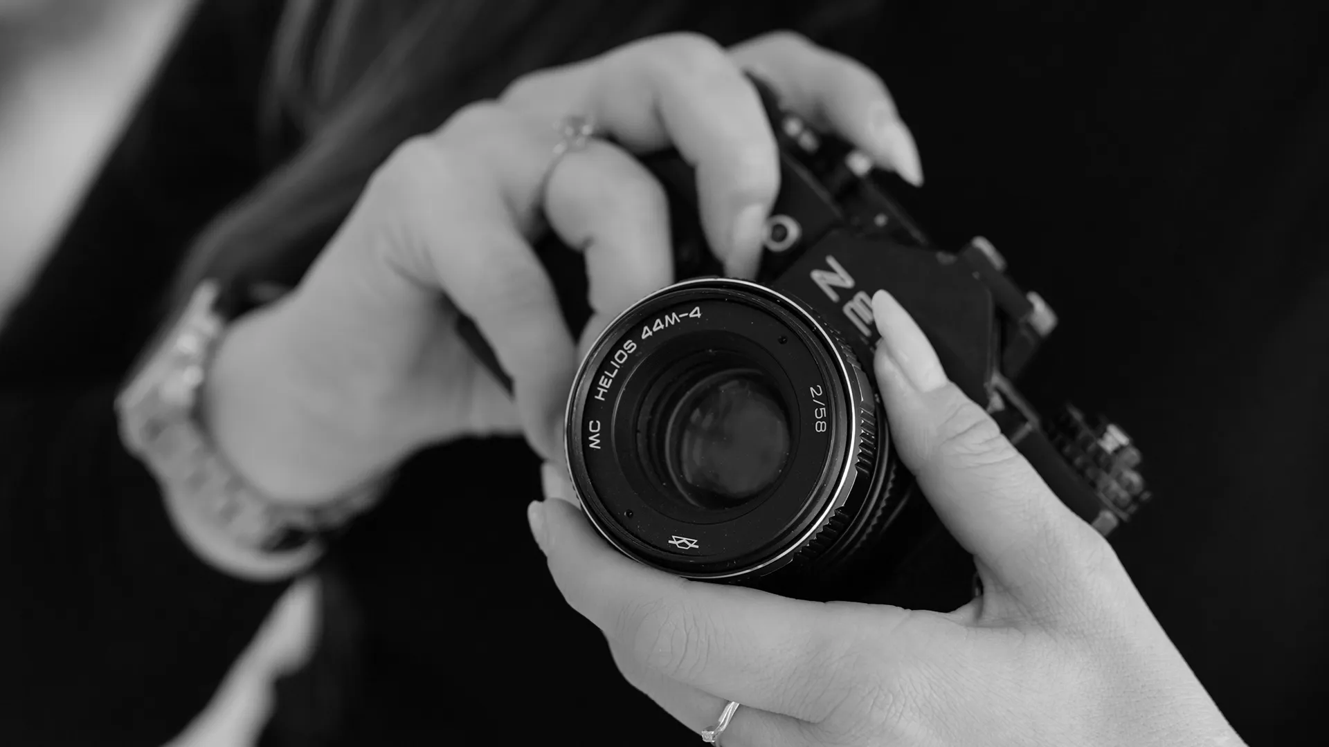Mãos segurando uma câmera fotográfica analógica, retrato em preto e branco — RM Foto e Filme, Brasília
