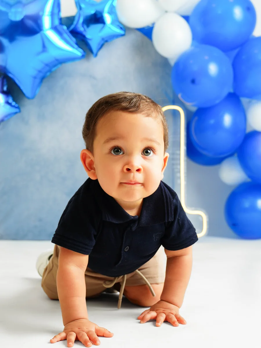 Bebê engatinhando em cenário com arco de balões azuis e o número 1 — Smash the Cake de 1 aninho, Brasília