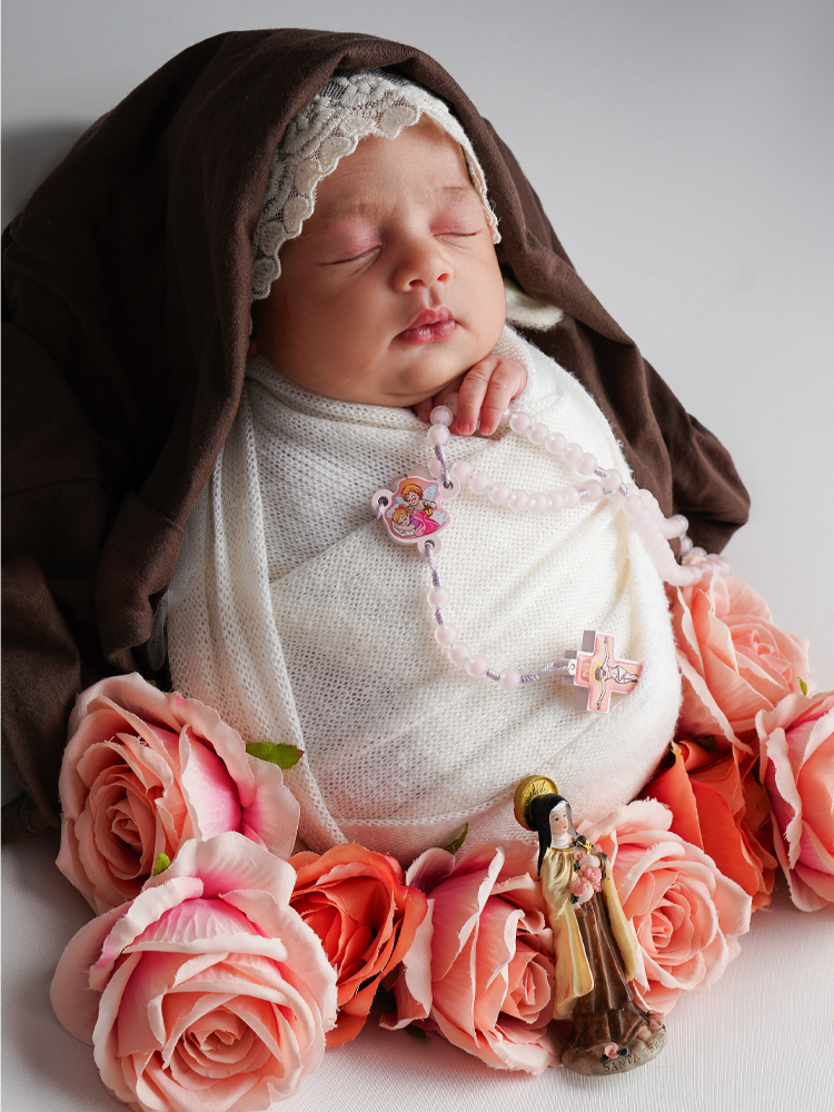 Newborn dormindo em tema devocional, com véu, terço e rosas — ensaio newborn temático em Brasília